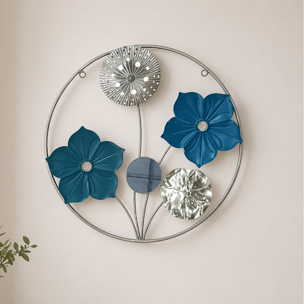 Decorative wall art with blue flowers and metallic elements on a plain wall.